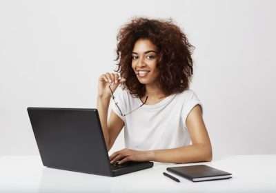 african-girl-smiling-sitting-wokplace-with-laptop_176420-11193